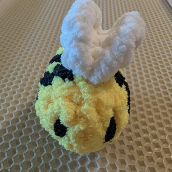 Plush bee toy on a honeycomb-patterned surface